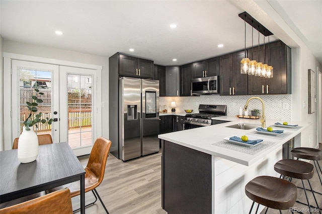 6775 Newland St, Arvada, CO 80003 - kitchen with appliances with stainless steel finishes, a sink, light countertops, a peninsula, and a breakfast bar
