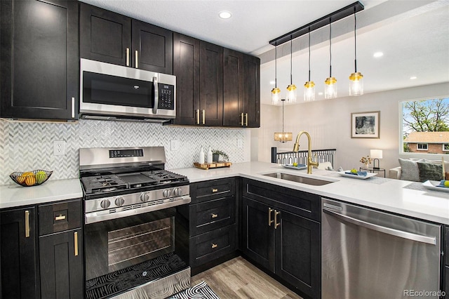 6775 Newland St, Arvada, CO 80003 - kitchen with appliances with stainless steel finishes, a sink, light wood-type flooring, backsplash, and light countertops