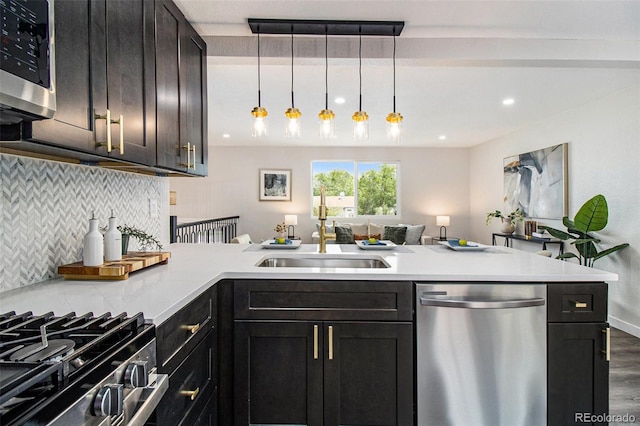 6775 Newland St, Arvada, CO 80003 - kitchen featuring stainless steel appliances, a sink, tasteful backsplash, a peninsula, and light countertops