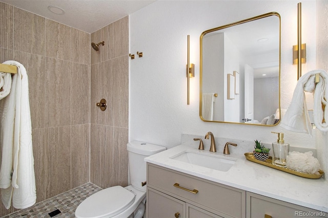 6775 Newland St, Arvada, CO 80003 - bathroom with vanity, tiled shower, and toilet