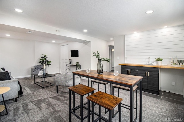 6775 Newland St, Arvada, CO 80003 - dining room featuring wet bar, recessed lighting, a textured ceiling, and dark colored carpet