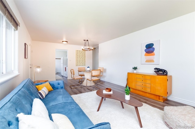 9100 Yucca Way, Thornton, CO 80229 - living area featuring wood finished floors, baseboards, and a notable chandelier