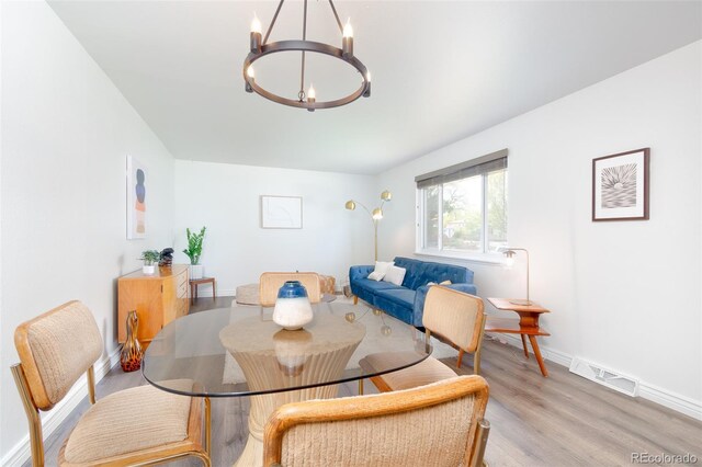 9100 Yucca Way, Thornton, CO 80229 - dining area featuring a chandelier, visible vents, wood finished floors, and baseboards