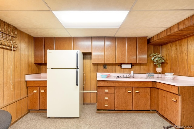 9100 Yucca Way, Thornton, CO 80229 - kitchen with freestanding refrigerator, wood walls, and a sink