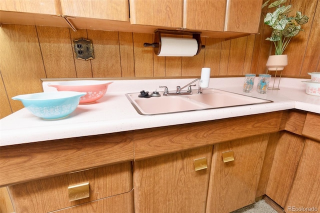 9100 Yucca Way, Thornton, CO 80229 - kitchen with brown cabinets, wooden walls, light countertops, and a sink