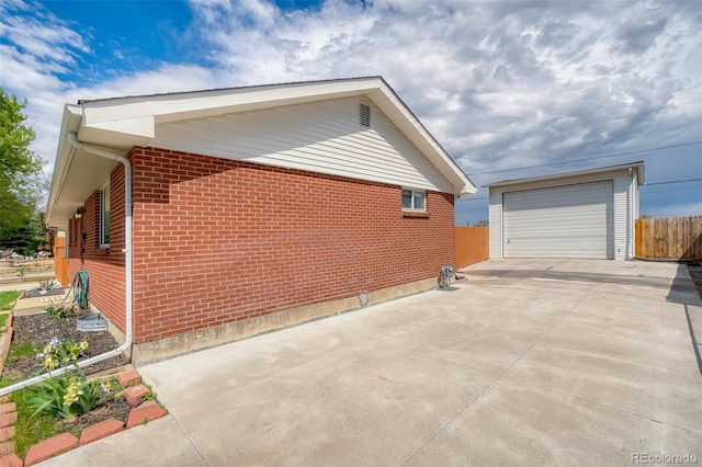 9100 Yucca Way, Thornton, CO 80229 - view of home's exterior with concrete driveway, brick siding, fence, and a detached garage