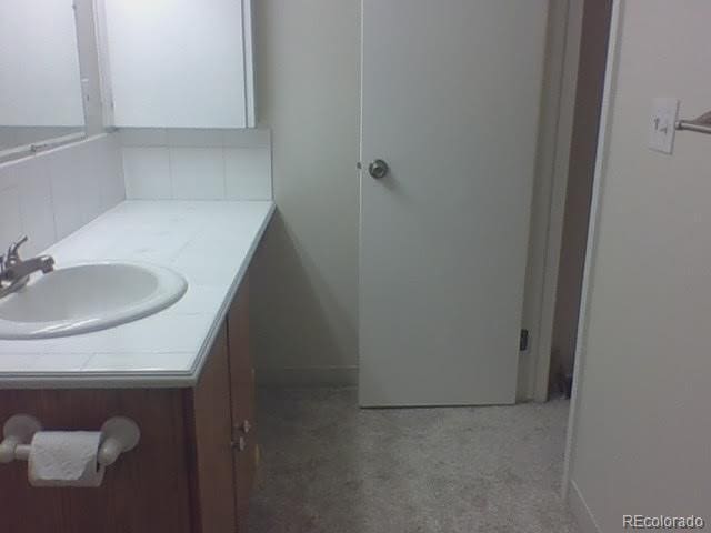 bathroom featuring vanity and backsplash