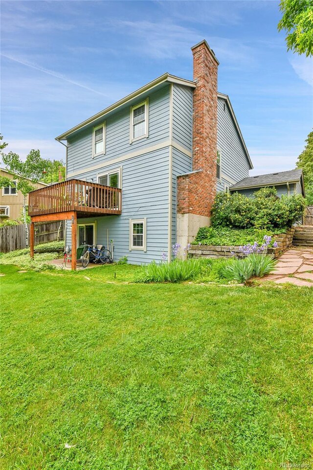 11404 W Sharkstooth Peak, Littleton, CO 80127 - back of house with a wooden deck and a chimney
