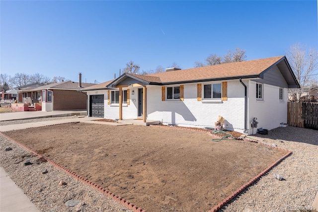 ranch-style house featuring an attached garage, fence, concrete driveway, and brick siding