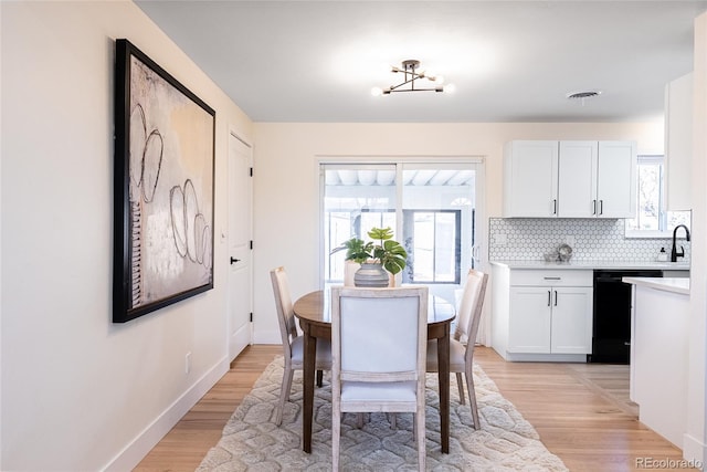 dining space featuring baseboards, visible vents, and light wood-style floors