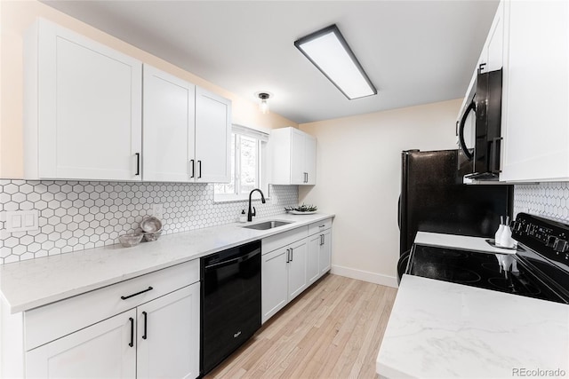 kitchen with white cabinetry, a sink, backsplash, and black appliances