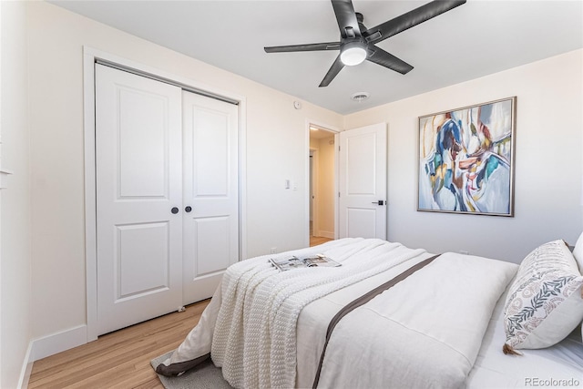 bedroom featuring a closet, visible vents, light wood-style flooring, ceiling fan, and baseboards