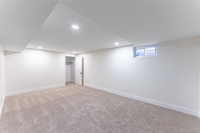 basement featuring light carpet, baseboards, and recessed lighting