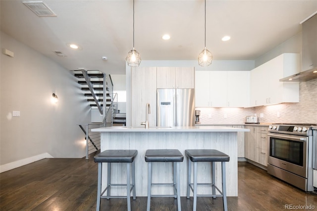 1323 Elati St Unit 3, Denver, CO 80204 - kitchen with appliances with stainless steel finishes, wall chimney range hood, backsplash, a kitchen breakfast bar, and light countertops