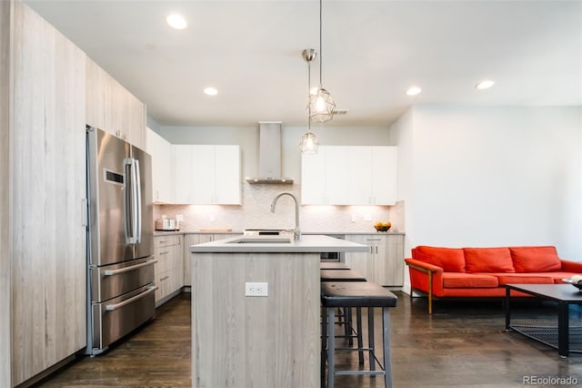 1323 Elati St Unit 3, Denver, CO 80204 - kitchen featuring freestanding refrigerator, wall chimney range hood, a breakfast bar area, dark wood finished floors, and recessed lighting