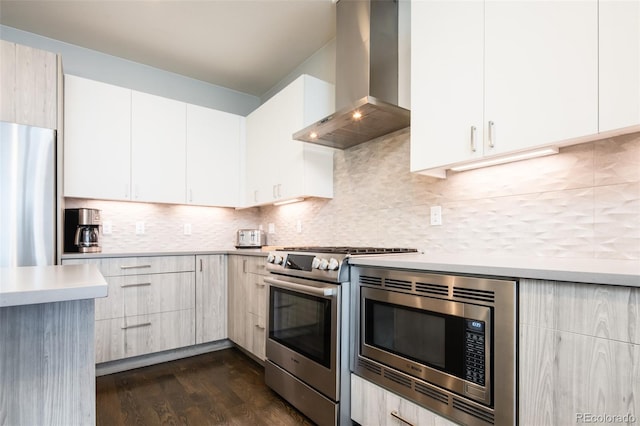 1323 Elati St Unit 3, Denver, CO 80204 - kitchen featuring wall chimney exhaust hood, stainless steel appliances, light countertops, dark wood-style flooring, and decorative backsplash