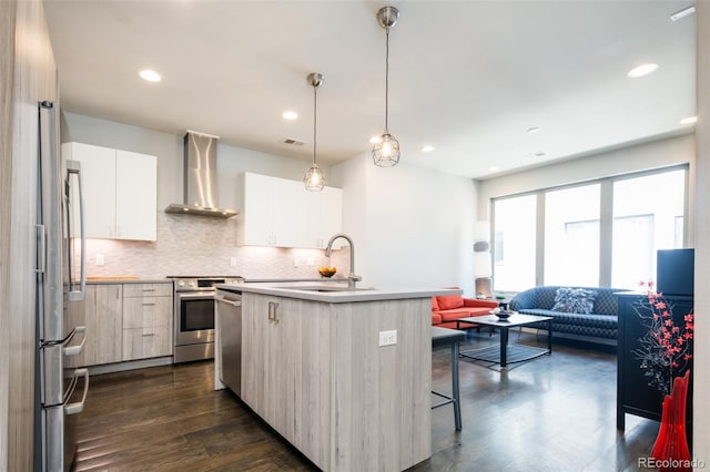 1323 Elati St Unit 3, Denver, CO 80204 - kitchen with wall chimney exhaust hood, a sink, stainless steel appliances, modern cabinets, and a kitchen island with sink