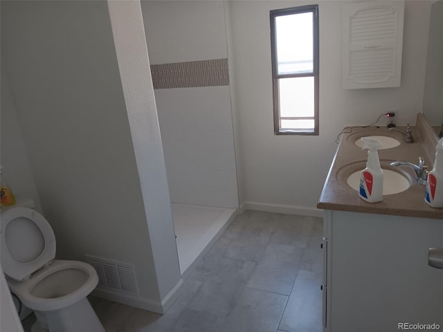 102 Jackson Dr, Firestone, CO 80520 - bathroom featuring toilet, vanity, a stall shower, and baseboards
