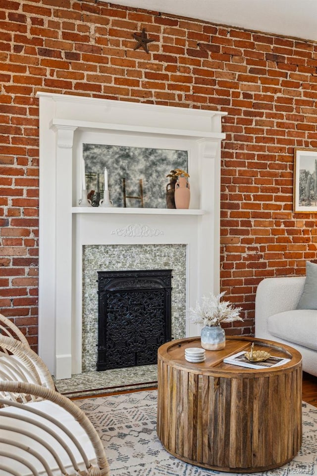 living room with a fireplace and brick wall