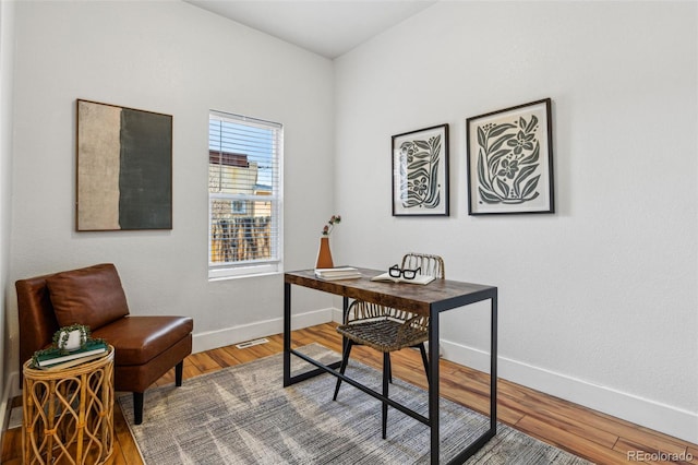 office space featuring visible vents, baseboards, and wood finished floors