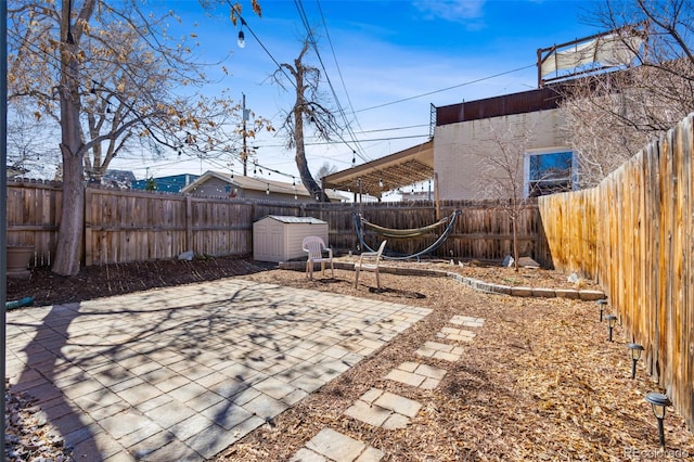 view of patio with a shed, an outdoor structure, and a fenced backyard