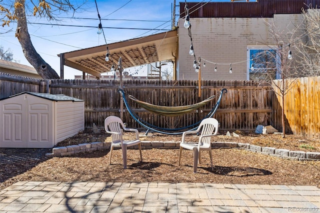 view of yard with a shed, a fenced backyard, and an outdoor structure