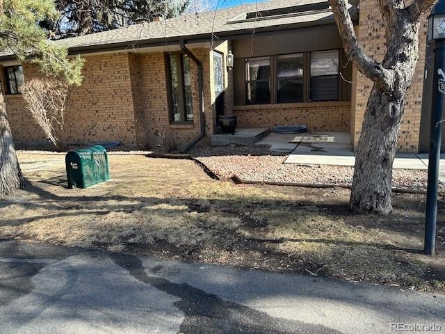 exterior space with brick siding and a patio