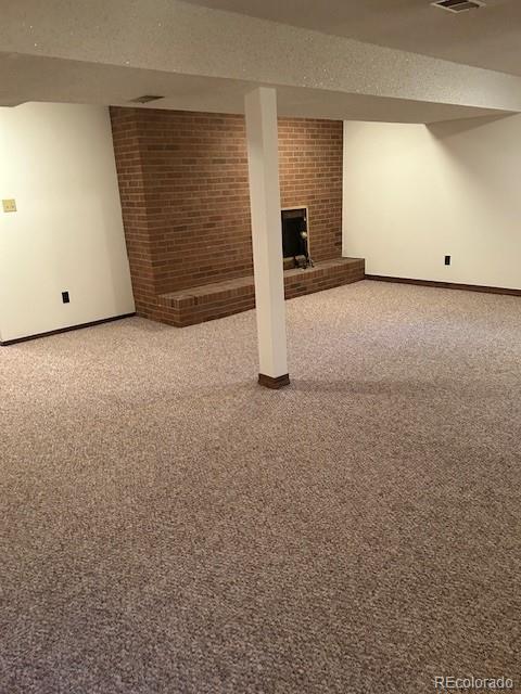 finished below grade area with carpet, visible vents, and baseboards