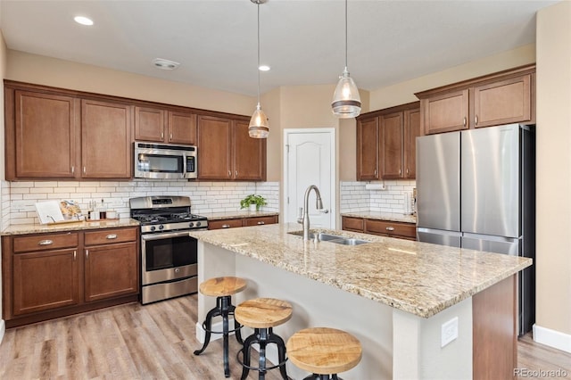 3319 Starry Night Loop, Castle Rock, CO 80109 - kitchen featuring appliances with stainless steel finishes, a sink, light wood-type flooring, light stone counters, and recessed lighting