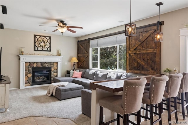 3540 Brushwood Dr, Castle Rock, CO 80109 - living room featuring a barn door, ceiling fan, carpet floors, tile patterned flooring, and a fireplace