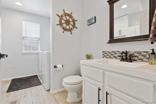 3540 Brushwood Dr, Castle Rock, CO 80109 - bathroom with vanity, washer / clothes dryer, decorative backsplash, wood finished floors, and recessed lighting