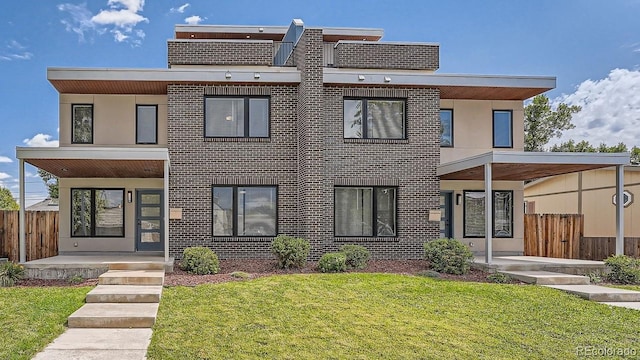 contemporary house featuring a front yard and a patio