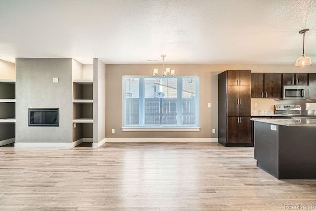 kitchen with decorative light fixtures, built in features, dark brown cabinetry, and appliances with stainless steel finishes