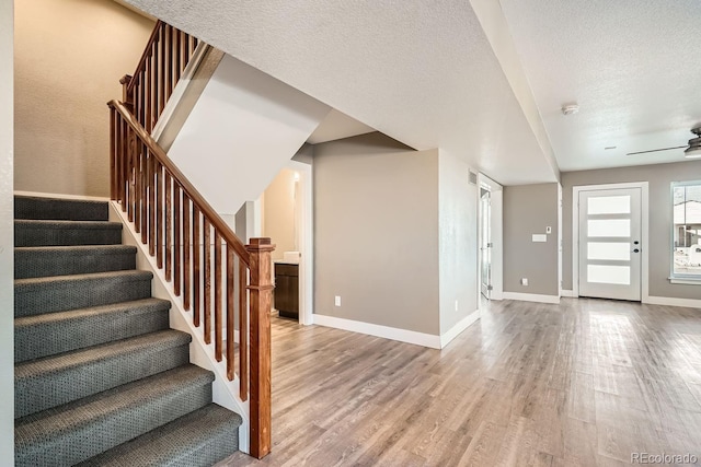 interior space with ceiling fan, a textured ceiling, and wood-type flooring