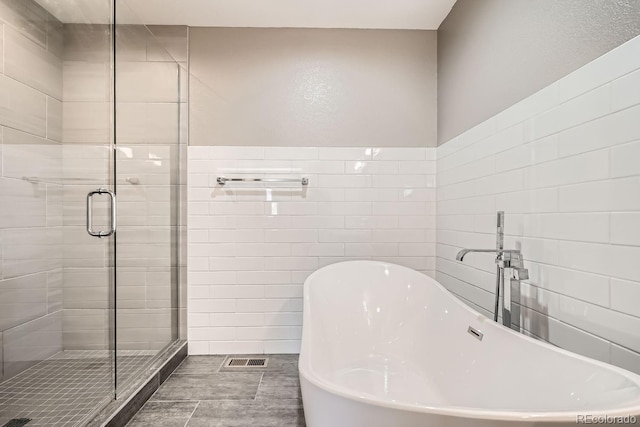 bathroom featuring sink, plus walk in shower, and tile patterned flooring