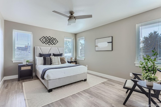 bedroom featuring light hardwood / wood-style floors, multiple windows, and ceiling fan