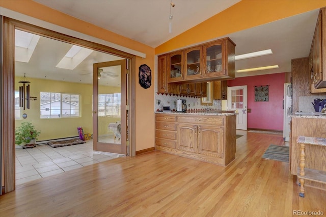 kitchen with decorative backsplash, light hardwood / wood-style flooring, and white refrigerator