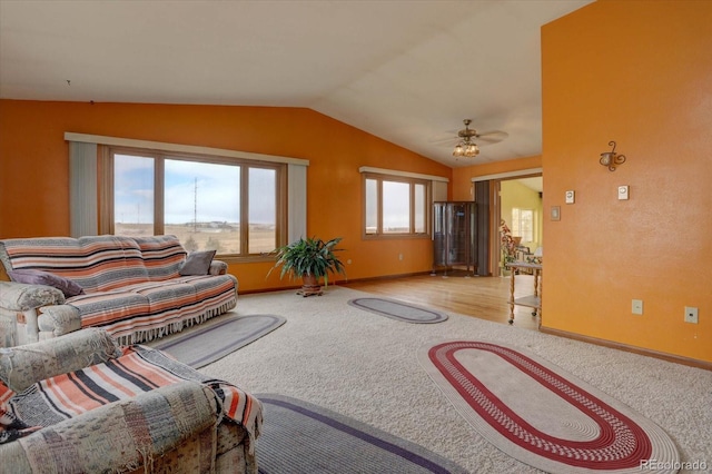 carpeted living room with ceiling fan and lofted ceiling