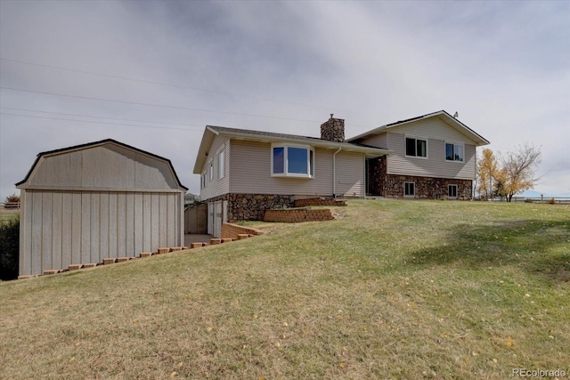 rear view of house with a storage unit and a lawn