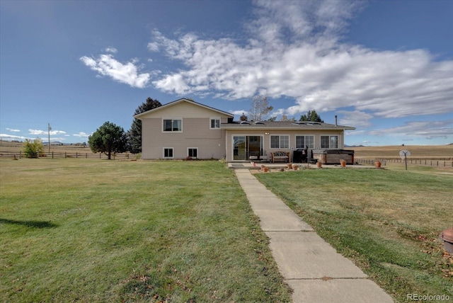 rear view of house featuring a rural view, a lawn, and a patio area