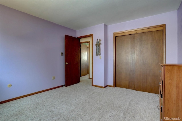 unfurnished bedroom featuring a closet and light colored carpet