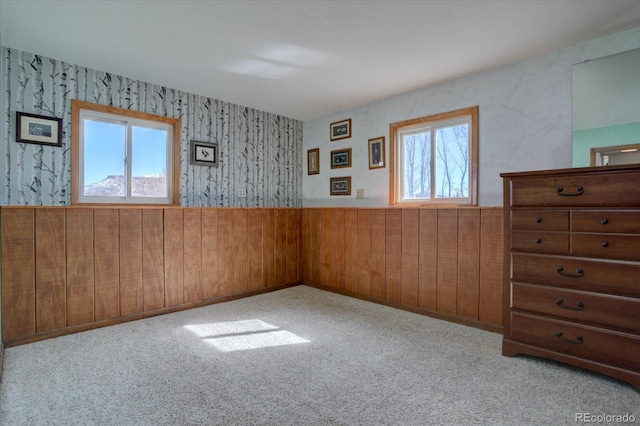 unfurnished room featuring wooden walls and light colored carpet