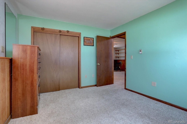 unfurnished bedroom with a closet and light colored carpet