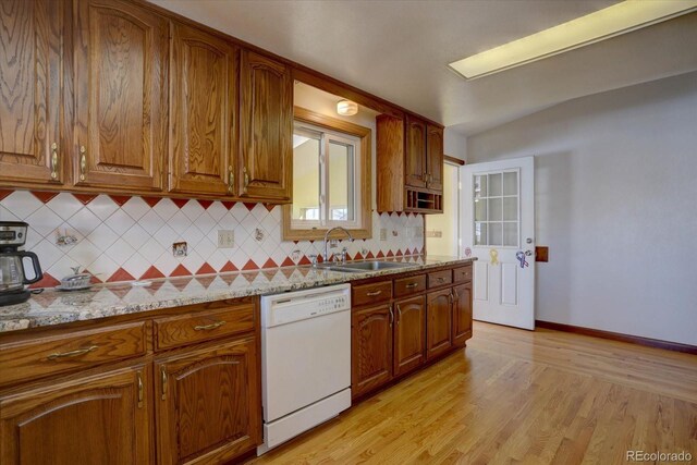 11810 Mesa View Rd, Larkspur, CO 80118 - kitchen featuring dishwasher, a sink, decorative backsplash, brown cabinetry, and vaulted ceiling
