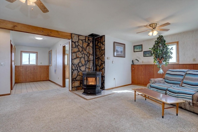 11810 Mesa View Rd, Larkspur, CO 80118 - carpeted living area featuring a ceiling fan, baseboards, a wood stove, and beamed ceiling