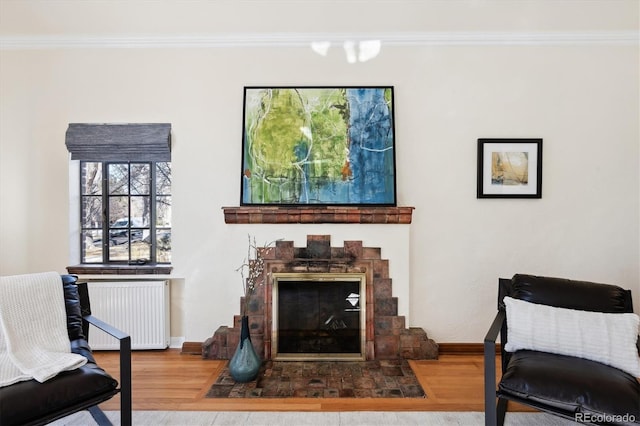 sitting room with ornamental molding, radiator, and hardwood / wood-style floors