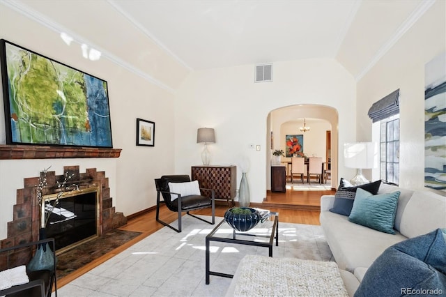 living room featuring hardwood / wood-style flooring, vaulted ceiling, and ornamental molding