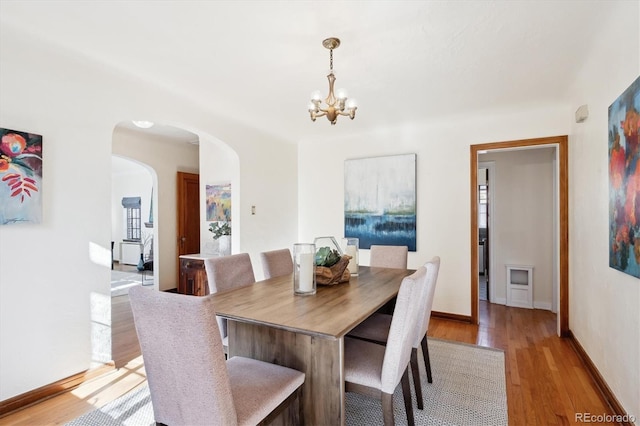 dining space with a chandelier and light hardwood / wood-style flooring