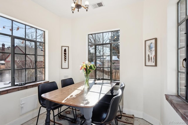 dining area featuring a healthy amount of sunlight and a chandelier