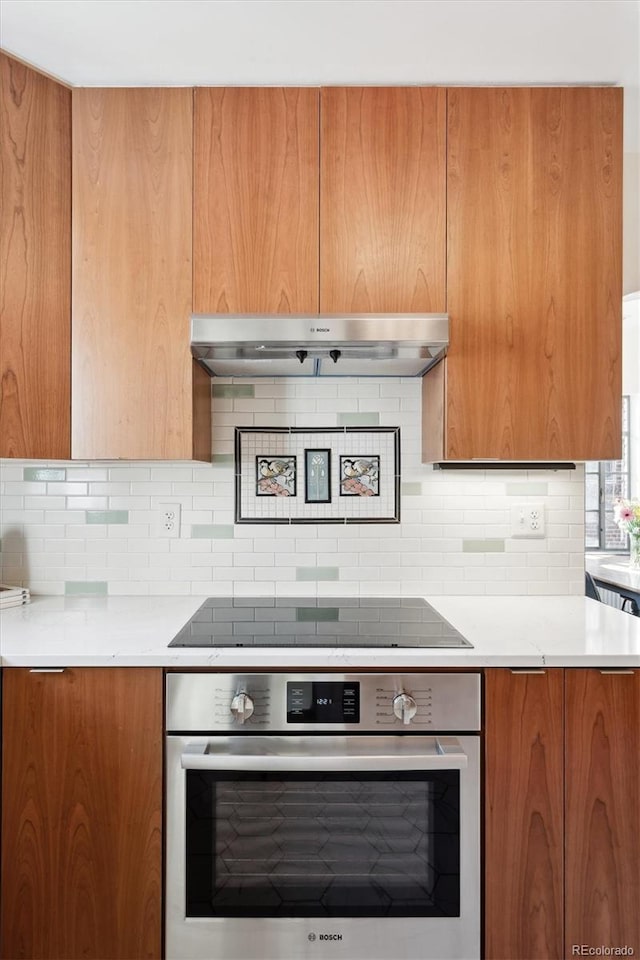 kitchen with stainless steel oven, black electric stovetop, and backsplash